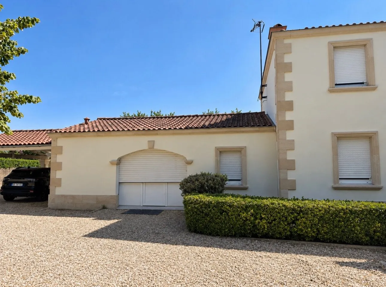 Maison avec garage, encadrements en pierre et cour en gravillons clairs